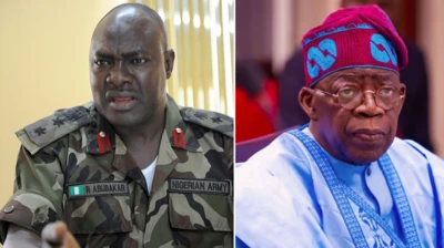 Military officer on im outfit wit bald head, anoda man dey beside wit glasses and cap on native attire