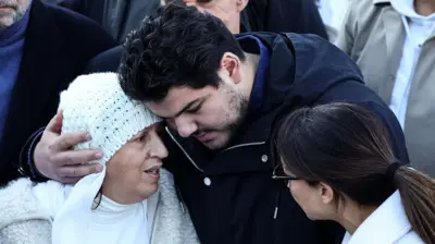 French anti-drug activist Amine Kessaci (C) and his mother Ouassila Benhamdi Kessaci (L) gather to take part in a march in tribute to Mehdi Kessaci at the roundabout where he was murdered and to protest against drug trafficking, in Marseille, southern France on November 22, 2025.