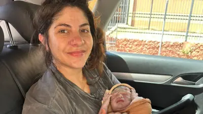 Lais segurando o filho logo após o nascimento dentro de um veículo