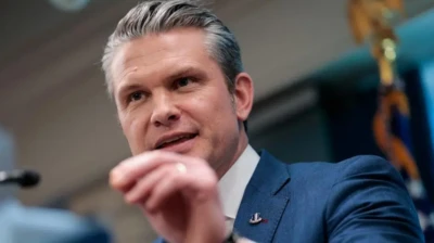 نمای نزدیک از چهره پیت هگست، پشت میکروفون در حال سخنرانی