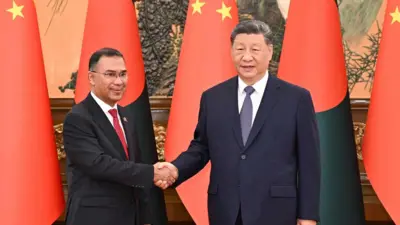 北京人民大会堂内,孟加拉总理塔里克(左)与中国国家主席习近平握手。两人身后摆放着两国国旗。(26/6/2026)