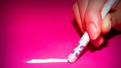 Carreiracbet uabum pó branco num fundo rosa, com uma mão segurando uma notacbet uabdinheiro enrolada como um canudo