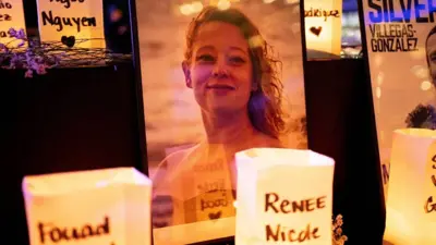 Velas encendidas junto a una imagen de Renee Good en una vigilia en Seattle
