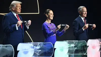 O presidente dos Estados Unidos, Donald Trump, a presidente do México, Claudia Sheinbaum, e o primeiro-ministro do Canadá, Mark Carney, mostram papéis com os nomes dos seus países, durante o sorteio dos grupos da Copa do Mundo da Fifa de Futebol Masculino 2026
