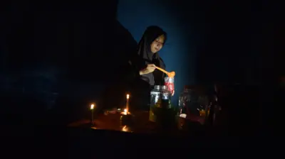 Pedagang menyiapkan minuman untuk pembeli saat pemadaman listrik di Nagari Kasang, Padang Pariaman, Sumatera Barat, Sabtu (23/05). Pemadaman listrik massal masih terjadi di sejumlah daerah di Sumatera Barat dengan waktu yang bergiliran di masing-masing daerah. 