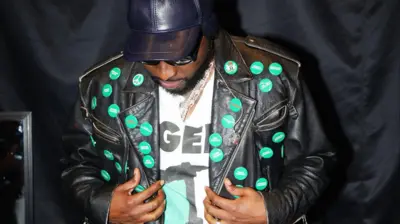 Davido wọ aṣọ dudu, o si de fila dudu pẹlu awo dudu loju rẹ
