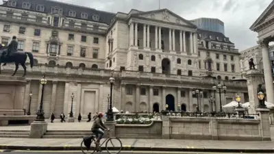 نمای بیرونی از عمارت، عابران پیاده و یک دوچرخه سوار که از مقابل عمارت میگذرد