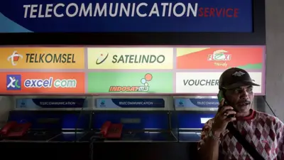 Seorang pria sedang berbicara lewat telepon genggamnya.