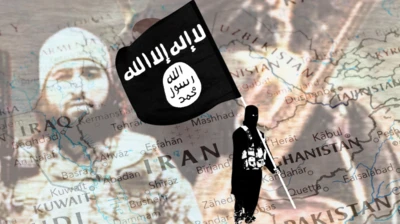 Elinde IŞİD bayrağı taşıyan bir militan. Arkada Horasan bölgesini gösteren harita var. En arkada silik bir şekilde bir başka IŞİD militanı görülüyor.