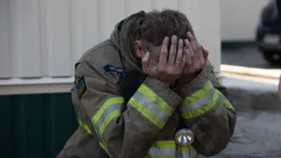 Спасатель плачет у здания типографии «Фактор-Друк», пострадавшей от российского обстрела 23 мая 2024 года в Харькове, Украина.