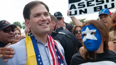 Marco Rubio con las banderas de Venezuela y EE.UU.
