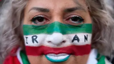 معترض ایرانی در پاریس که صورتش را به صورت پرچم ایران رنگ کرده است