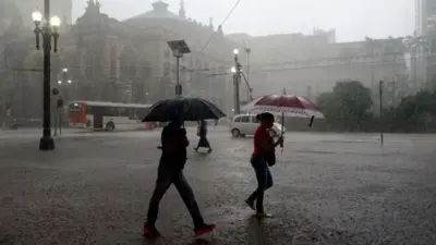 Pessoas caminham durante tempestade no centroapostas futebol dicas hojeSão Paulo