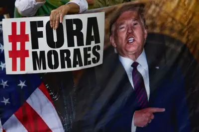Pessoa segura cartaz que diz "Fora Moraes" ao lado de grande imagem de Donald Trump