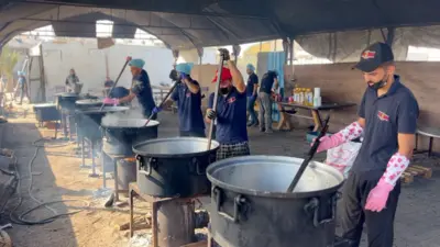Cooks stir pots of rice and lentils at a community food kitchen run by the US-based humanitarian organisation Anera in Khan Younis, southern Gaza
