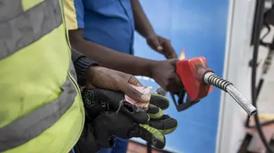 Kenyan fuel attendant selling fuel