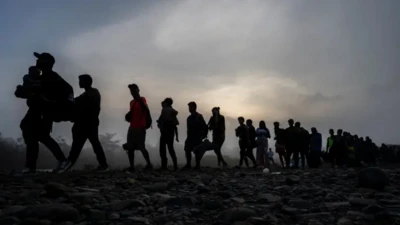 صفی از پناهجویان در تاریکی شب حرکت می‌کنند