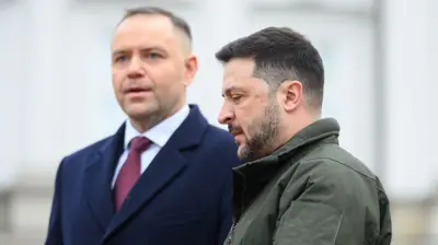 Prezydent Polski Karol Nawrocki (z lewej) w granatowym płaszczu, białej koszuli i czerwonym krawacie stoi obok prezydenta Ukrainy Wołodymyra Zełenskiego (z prawej), który ma na sobie zieloną kurtkę w stylu wojskowym