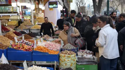 مشتریان مشغول خرید از یک مغازه در بازار بزرگ تهران در اسفندماه ۱۴۰۴