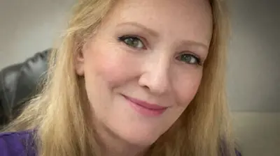 Uma foto de uma mulher loira olhando para a câmera.