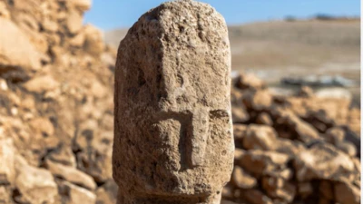 A T-shaped pillar bearing a carved human face