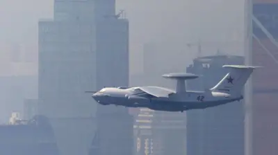 Самолет-радар А-50 в воздухе на фоне высотных домов