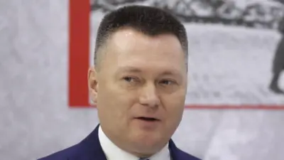 Мужчина с короткой стрижкой и легкой улыбкой на лице