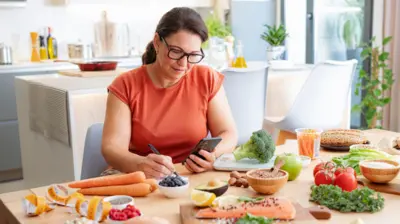 Akıllı telefonunu kullanan bir kadın, dengeli beslenme, metabolizmayı hızlandırma ve obezite kontrolü için çevrimiçi olarak sağlıklı tarifler arıyor