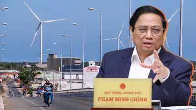 Ảnh thiết kế: Thủ tướng Phạm Minh Chính đang phát biểu, hình nền phía sau là tua bin gió nhìn từ cầu Mỹ Thành, thị trấn Vĩnh Châu, tỉnh Sóc Trăng