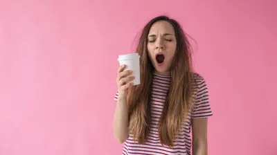 دختری لیوان بدست خمیازه می‌کشد