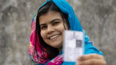 Woman holding ballot in 2024 India elections