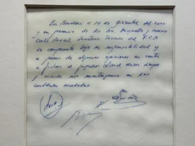 Una servilleta con un mensaje que se lee “En Barcelona, a 14 de diciembre de 2000 y en presencia de los señores Minguella y Horacio, Carles Rexach, director deportivo del FC Barcelona, se compromete, bajo su responsabilidad y con independencia de cualquier opinión contraria, a fichar al jugador Lionel Messi, siempre que se respeten las cantidades acordadas”.