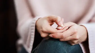 Przycięte ujęcie kobiety siedzącej na sofie i odczuwającej niepokój