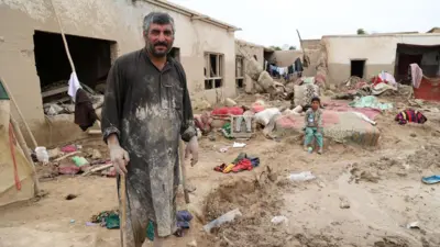 یک مرد در میان گل و لای ناشی از سیل 
