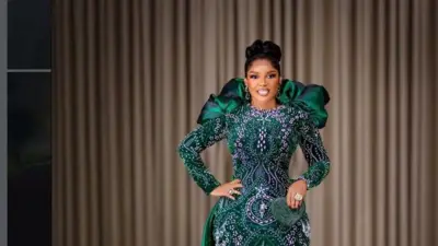 Iyabo Ojo, o wọ kaba alawọ ewe to ni funfun lara o si mu apamọwọ kekere kan dani