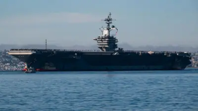 USS Abraham Lincoln Aralık 2024'te San Diego'ya yaklaşırken yüzlerce denizci güvertede yan yana durmuş 