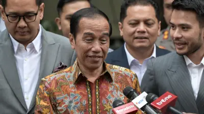 Presiden ketujuh Joko Widodo (tengah) menjawab pertanyaan wartawan di depan Gedung Direktorat Reserse Kriminal Umum Polda Metro Jaya, Jakarta, Rabu (30/4/2025).