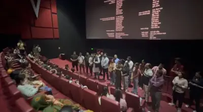 सिनेमा हॉल में शपथ दिलाते लोग