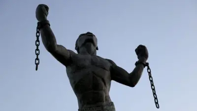 A statue of an enslaved person breaking their shackles.