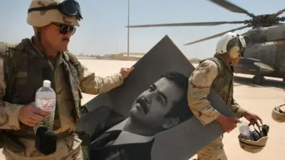 14 अप्रैल 2003 को बगदाद एयरपोर्ट पर अमेरिकी सैनिक सद्दाम के पोर्टेट के साथ