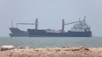Fotografia colorida mostra dois navios no mar no estreito de Ormuz