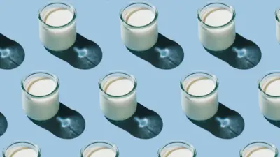 Soluk mavi bir arka plan üzerinde çapraz çizgiler halinde dizilmiş küçük kefir bardakları.