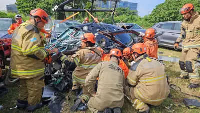 Agentes do corpo de bombeiros trabalham nos escombros de helicóptero envolvido em acidente