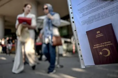 30 Haziran 2026 tarihinde İstanbul'da Schengen vizesine başvurmak üzere vize başvuru merkezinin önünde sıra bekleyen insanların olduğu bir ortamda, Türk vatandaşı bir vize başvuru sahibinin pasaportu görülüyor. Avrupa Komisyonu tarafından yayınlanan verilere göre, 2025 yılında Türkiye'den Schengen Bölgesi'ne (çoğunluğu Avrupa Birliği üyesi olan 26 ülke) yapılan 1,25 milyon vize başvurusunun 1,07 milyonu onaylanmıştır.