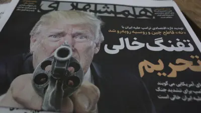 2026年8月22日,伊朗德黑蘭一家報攤外擺放的伊朗日報《Hamshahri》。報紙刊登美國總統特朗普的照片,以及波斯語標題「制裁的空槍」,報導特朗普針對伊朗發出的新一輪嚴厲經濟威脅。