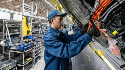 Empleado en una línea de producción de automóviles eléctricos en una fábrica de Seres en China.