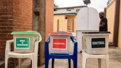Ballot boxes ontop chairs as man casts im vote at di polling station in Lagos.