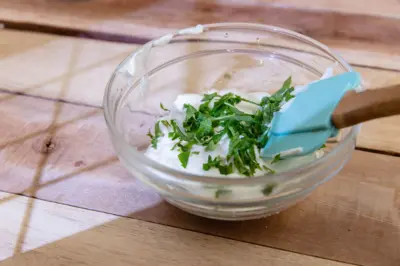 یک کاسه کوچک ماست با مقداری سبزیجات روی آن