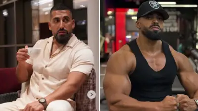 Di late Sina Ghami wear short sleeve two-piece cloth wey resemble light pink e hold tea cup for hand as e sitdown for chair dey look sideways into di camera. Kevin Ayodele wear balck sibglet with black face cap wey get logo wey no too clear. E pose as e sit for chair dey display im muscles.