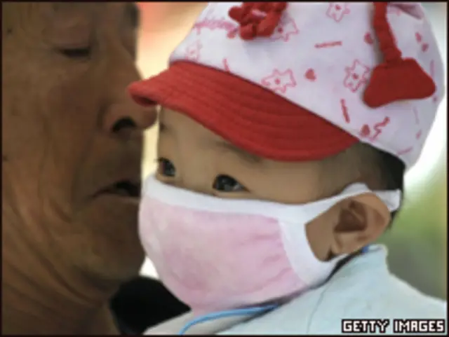 Bebê com máscara respiratória em Pequim
